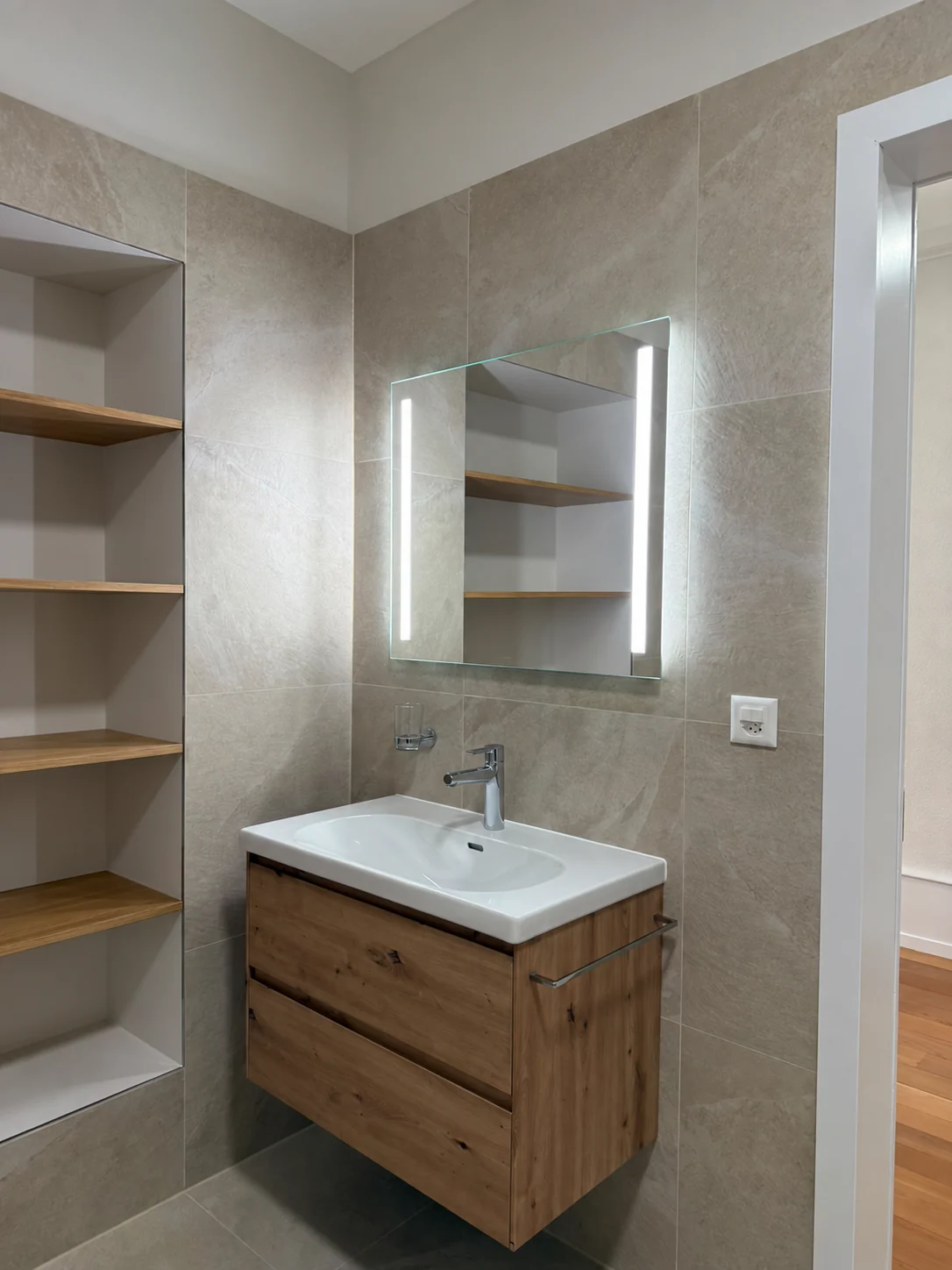 Meuble vasque en bois et miroir éclairé.