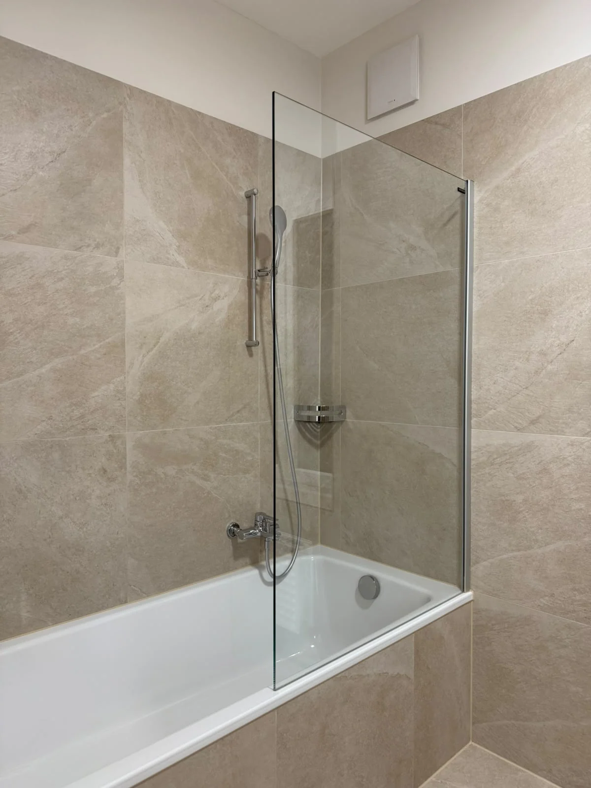 Baignoire avec paroi vitrée et douche.