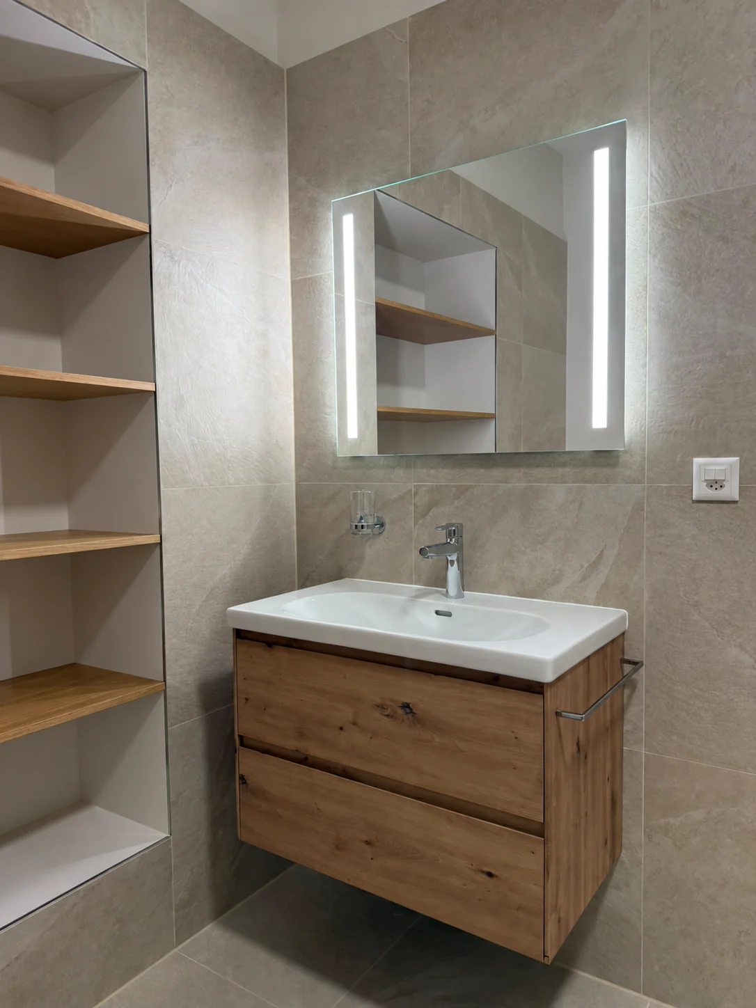 Meuble vasque en bois et miroir éclairé.